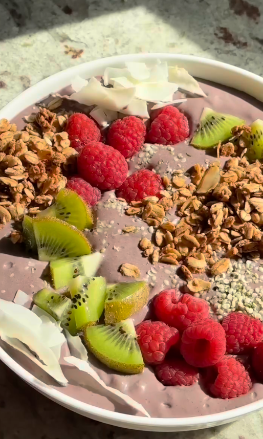 Acai bowl with granola, raspberries, and kiwi slices made using Goode health or Açaí Bowl