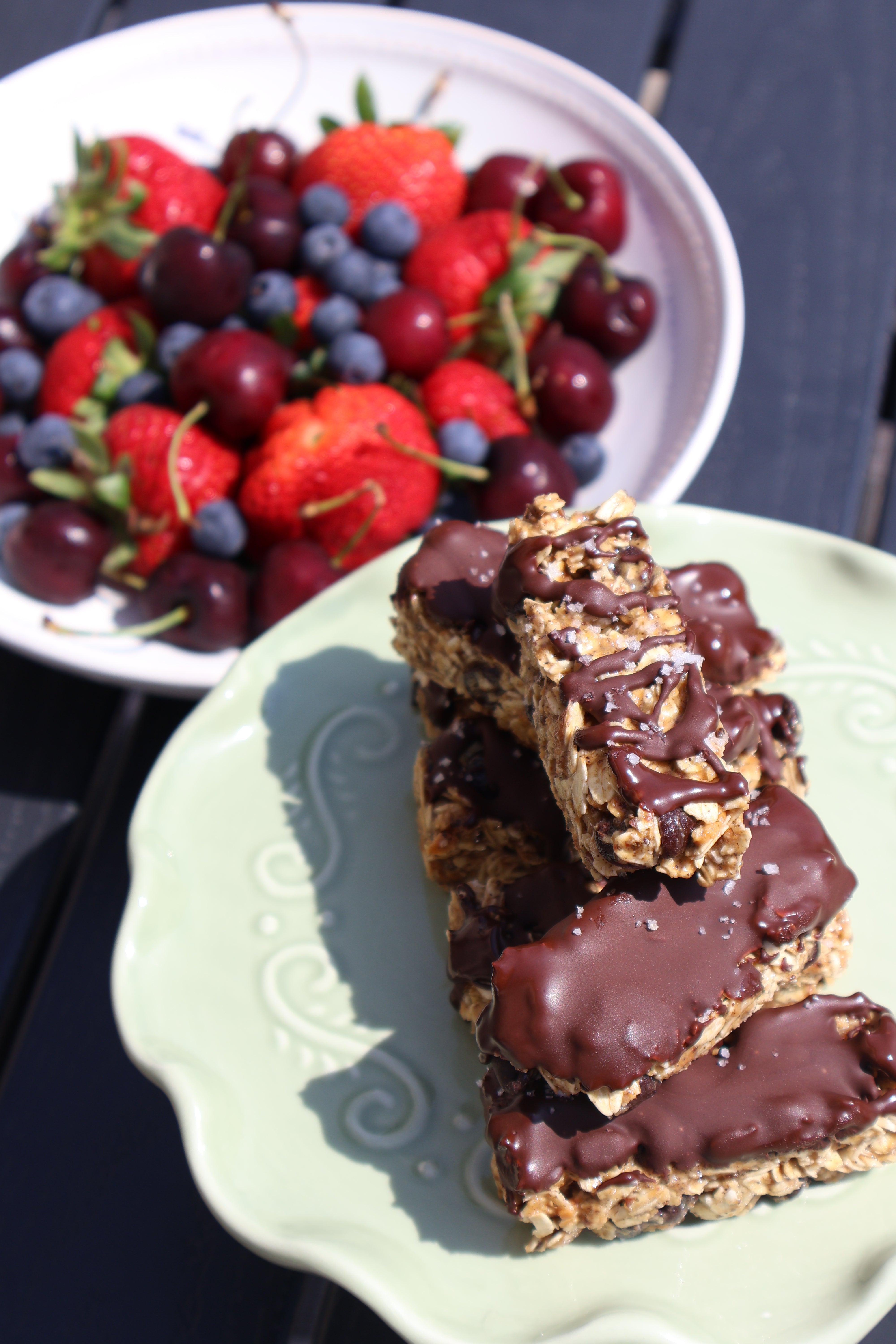 No bake protein granola bars made using Goode health with a bowl of berries in the background or No-bake Protein Granola Bars