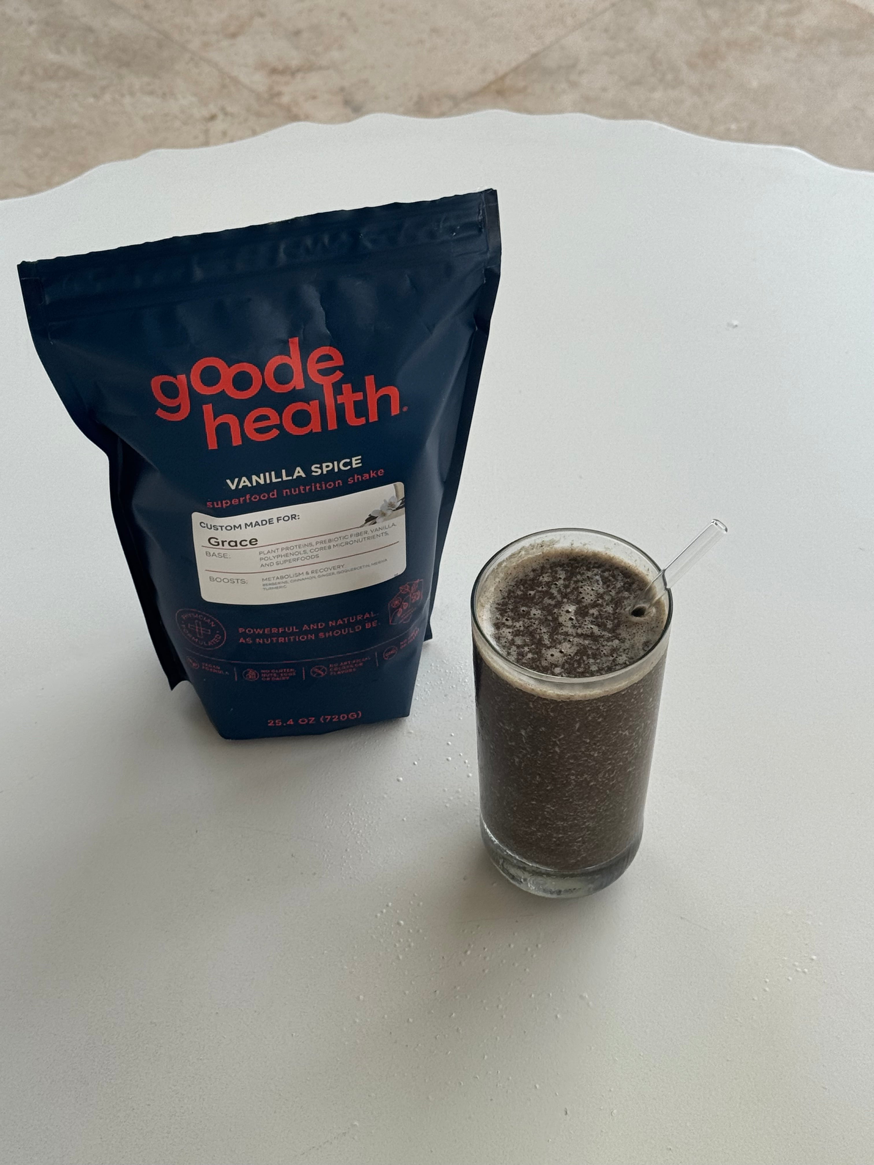 Bag of Goode Health vanilla spice powder next to a glass a wild berry greens smoothie made using Goode health or Wildberry Greens Smoothie