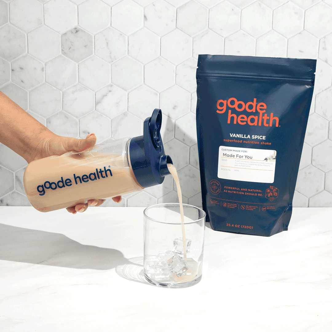 Woman pouring Goode health vanilla spice superfood nutrition shake into glass, with bag on counter